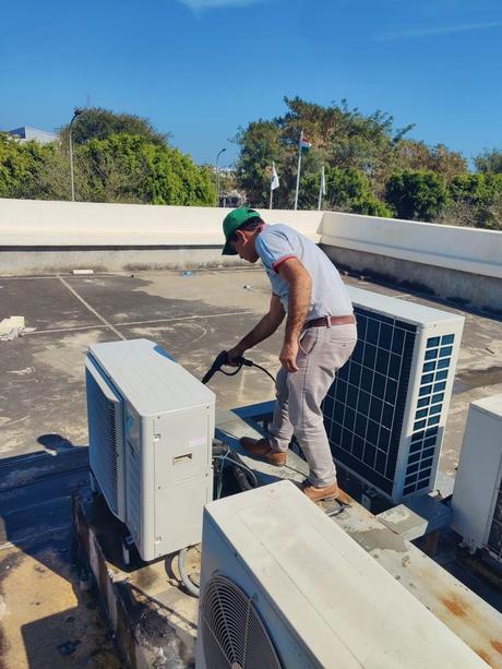 Technician at rooftop condensers